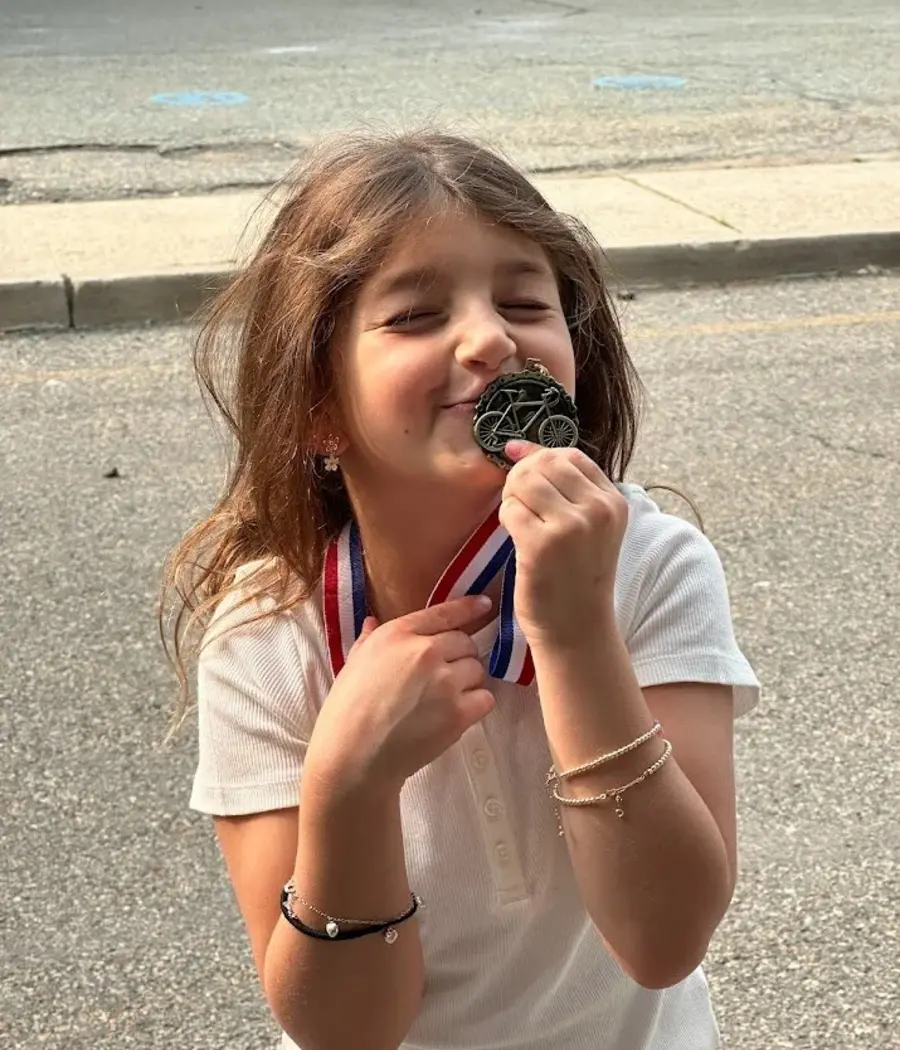 A child proudly showing a medal after a Ready to Pedal lesson